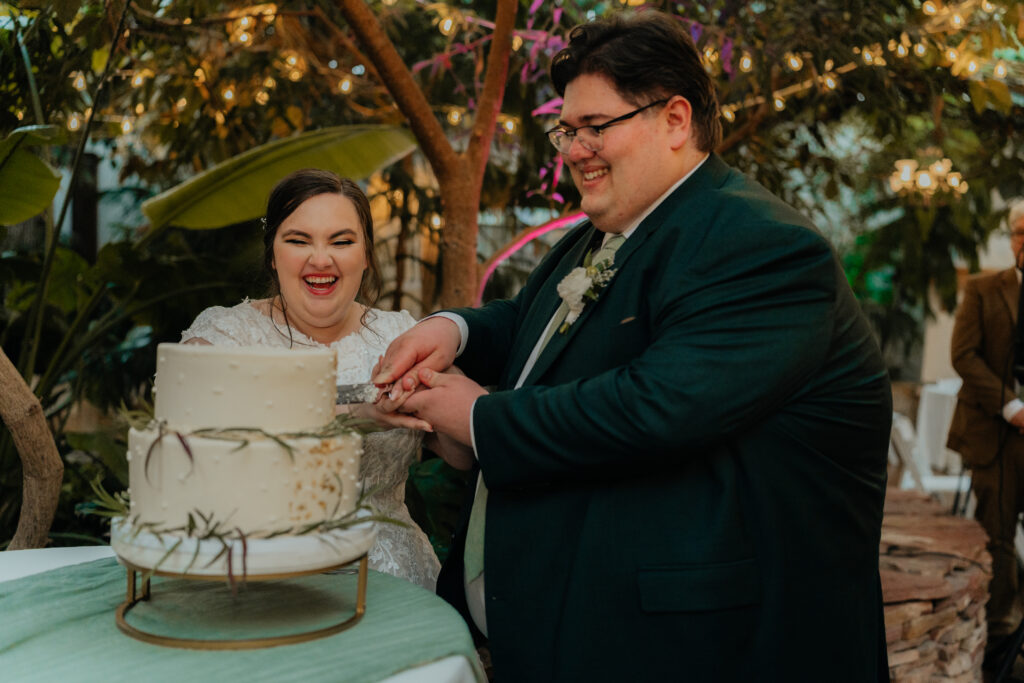 Bride and groom cutting cake at wedding reception